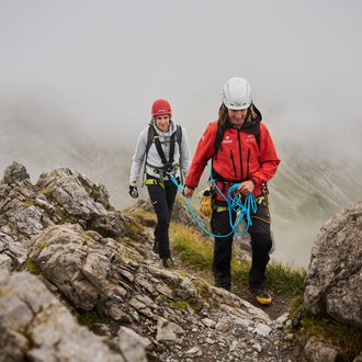 © Bergschule Kleinwalsertal | Oliver Farys Zwei Bergsteiger bewegen sich an einem felsigen Hang. Es ist neblig und die Umgebung wirkt wild und unberührt. | © Bergschule Kleinwalsertal | Oliver Farys