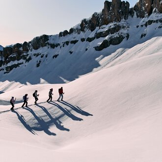 © Kleinwalsertal Tourismus eGen | Oliver Farys Eine Gruppe von Wanderern geht über eine schneebedeckte Landschaft. Im Hintergrund sind majestätische Berge zu sehen. | © Kleinwalsertal Tourismus eGen | Oliver Farys
