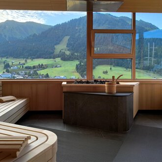© Hotel Erlebach GmbH Ein modernes Wellness-Spa mit Holzbänken und einem schönen Blick auf die Berge. Große Fenster bieten viel Tageslicht und eine entspannende Aussicht auf die Natur. | © Hotel Erlebach GmbH
