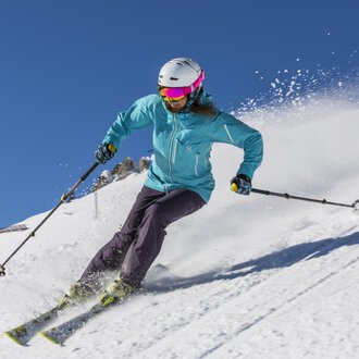 © GENUSS & AKTIVHOTEL SONNENBURG A skier is riding on a snowy slope. The clear blue sky and the snow create a beautiful winter atmosphere. | © GENUSS & AKTIVHOTEL SONNENBURG
