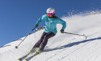 © GENUSS & AKTIVHOTEL SONNENBURG A skier is riding on a snowy slope. The clear blue sky and the snow create a beautiful winter atmosphere. | © GENUSS & AKTIVHOTEL SONNENBURG
