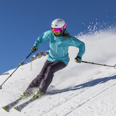 © GENUSS & AKTIVHOTEL SONNENBURG A skier is riding on a snowy slope. The clear blue sky and the snow create a beautiful winter atmosphere. | © GENUSS & AKTIVHOTEL SONNENBURG