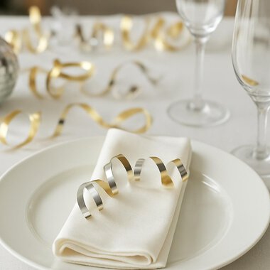 A festively set table with a red candle and a poinsettia. The decoration is surrounded by fir branches and berries. | © KI generiert Kleinwalsertal Tourismus