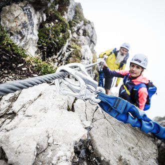 © Bergschule Kleinwalsertal | Dominik Berchtold Zwei Kletterer sichern sich an einem steilen Felsen. Es ist neblig und die Umgebung wirkt herausfordernd und abenteuerlich. | © Bergschule Kleinwalsertal | Dominik Berchtold