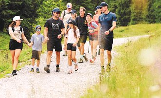 A group of people is hiking on a forest path. They enjoy nature and the time spent together outdoors. | © Kleinwalsertal Tourismus | Oliver Farys