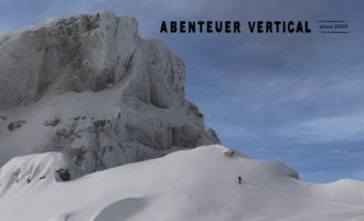 Eine beeindruckende Berglandschaft mit schneebedeckten Gipfeln und einem klaren Himmel. Eine Person erkundet die alpine Umgebung.