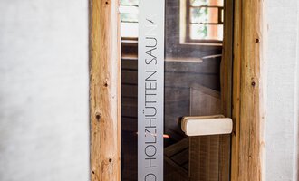A modern entrance to a room with a wooden frame and glass door. The space conveys an inviting and relaxing atmosphere. | © Verwöhn- & Wellnesshotel Walserhof| Aileen Melucci