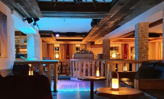 A cozy bar with wooden decor and soft lighting. The seating areas invite you to relax. | © Hotel Steinbock