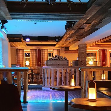 A cozy bar with wooden decor and soft lighting. The seating areas invite you to relax. | © Hotel Steinbock