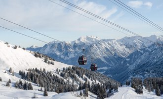 Eine Winterlandschaft mit schneebedeckten Bergen und Ski-Liften. Im Hintergrund sieht man eine klare Himmel und schöne Tannenbäume. | © OBERSTDORF · KLEINWALSERTAL BERGBAHNEN