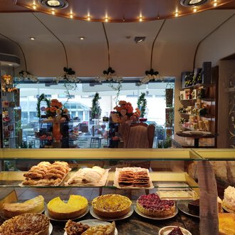 A cozy pastry shop with a selection of delicious baked goods. The space is brightly lit and offers a view of a beautiful courtyard. | © Kleinwalsertal Tourismus | N. Lughammer