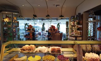 A cozy pastry shop with a selection of delicious baked goods. The space is brightly lit and offers a view of a beautiful courtyard. | © Kleinwalsertal Tourismus | N. Lughammer