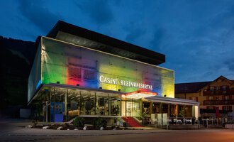 A modern casino with colorful lights at dusk. It is located in the Kleinwalsertal and has stylish architecture. | © Casinos Austria | Arnd Ötting