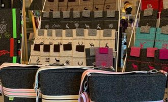 Three stylish felt bags with colorful stripes are in the foreground. In the background, there are additional bags in various colors and designs. | © Chrömle Schönes aus Filz | Anke Drechsel