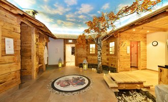 A cozy wellness area with wooden paneling and beautiful tree decorations. The ceiling features a clear sky, creating a relaxing atmosphere. | © Hotel Alpenstüble Appartements | Manuel Riezler