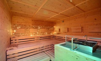 A cozy sauna with a wooden bench and soft lighting. The room radiates relaxation and warmth. | © Hotel Alpenstüble Appartements | Manuel Riezler