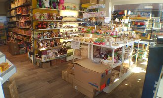 A cozy toy store with colorful shelves full of toys. In the middle are tables with additional items and boxes. | © Der Bunte Laden | Romana Volderauer