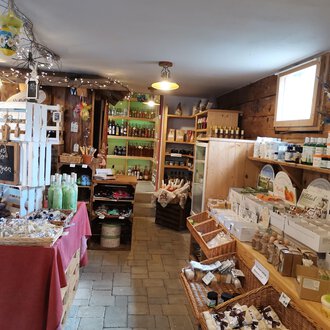 A cozy store with wooden walls that offers various products such as gifts and local foods. The ambiance is inviting and friendly. | © Dies & Das Hofladen | V. Wächter