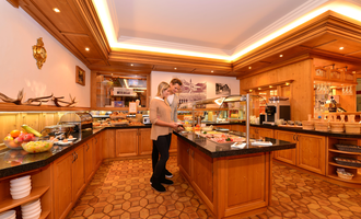 A stylish buffet in a cozy restaurant. Two people enjoy the selection of food and drinks.