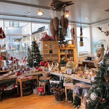An inviting gift shop with festive decorations. Christmas trees and lovingly designed products can be seen everywhere. | © HUIMWEA Alpendekor