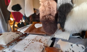 A selection of decorative cushions and fur materials. The cushions are designed in various colors and patterns. | © iKuh Schöne Ideen | Daniela Neumann