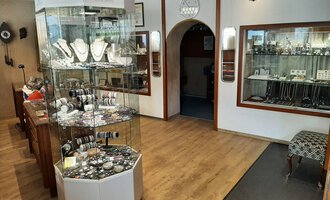 A jewelry store with a jewelry display in the center. Additional pieces of jewelry are displayed in showcases on the walls. | © Juwelier Demsky Walser Goldschmiede| Veronika Senn