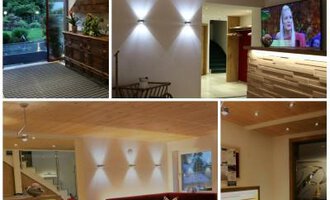 A modern interior design with wooden elements and warm lighting. Various areas offer seating and a television. | © Hotel Bellevue | I. Malouvier