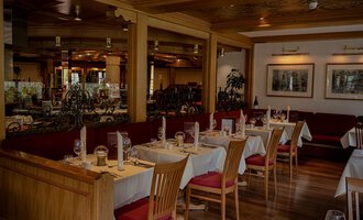 A cozy restaurant with wooden tables and chairs. The decor is warm and inviting, perfect for a pleasant meal. | © IFA Hotel Alpenhof Wildental | Andreas Froschauer