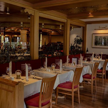 A cozy restaurant with wooden tables and chairs. The decor is warm and inviting, perfect for a pleasant meal. | © IFA Hotel Alpenhof Wildental | Andreas Froschauer