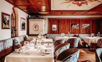 An elegant restaurant with wood paneling and stylish tables. The cozy atmosphere is enhanced by the decorative pictures and tasteful furnishings. | © Hotel Birkenhöhe | Sascha Gast