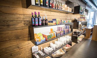A modern store with shelves full of drinks and groceries. The walls are made of wood, creating a cozy atmosphere. | © Kleinwalsertal Tourismus | Frank Drechsel