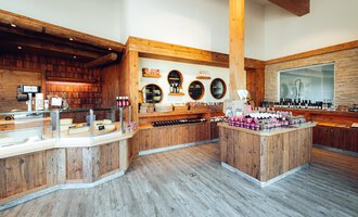 A modern store with plenty of wooden decor and shelves full of products. The cozy atmosphere invites browsing. | © XOND | Jodok Fritz